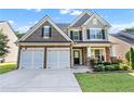 Charming two-story home with a two-car garage, manicured lawn, and stone and siding facade at 2481 Southhaven Ln, Buford, GA 30519