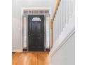 Welcoming foyer featuring a dark wood front door, gleaming wood floors, and white staircase at 1469 Crescent Walk, Decatur, GA 30033