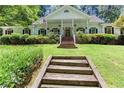 Inviting home featuring lush landscaping, a charming porch, and a well-maintained front yard at 5491 Hiram Rd, Powder Springs, GA 30127