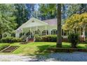 Charming home with lush landscaping, a covered porch, and classic architectural details at 5491 Hiram Rd, Powder Springs, GA 30127