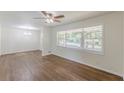 Bright living room with hardwood floors, large windows, and modern ceiling fan at 2416 Timber Ridge Ct, Decatur, GA 30032