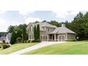 Well-maintained two-story home showcasing a lush lawn and spacious three-car garage at 240 Chandler Walk, Loganville, GA 30052