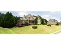 Suburban home with lush lawn, attractive landscaping, and neighboring house at 240 Chandler Walk, Loganville, GA 30052