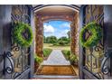 Ornate wrought-iron double doors leading to a beautifully landscaped front yard at 4239 Lower Jersey Rd, Covington, GA 30014