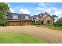 Charming stone home featuring a curved driveway and attached three-car garage at 4239 Lower Jersey Rd, Covington, GA 30014