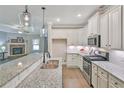 Modern kitchen with white cabinets, granite countertops, stainless steel appliances, and hardwood floors at 4571 Academy St, Acworth, GA 30101