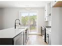 Bright kitchen with a spacious island, stainless steel appliances, and a sliding glass door to a balcony at 7230 Summit Pl, Alpharetta, GA 30009