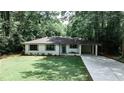 Charming brick home with manicured lawn, blue front door, and a convenient porte cochere at 437 Valley Brook Ne Dr, Atlanta, GA 30342