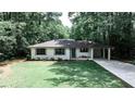 Charming brick home with manicured lawn, blue front door, and a convenient porte cochere at 437 Valley Brook Ne Dr, Atlanta, GA 30342