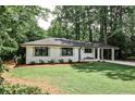 Charming brick home with manicured lawn, blue front door, and a convenient porte cochere at 437 Valley Brook Ne Dr, Atlanta, GA 30342