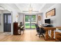Sunlit living room features hardwood floors, tray ceiling, and large windows offering views of the well-manicured lawn at 2085 Castle Royale Dr, Lawrenceville, GA 30043