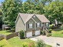 Elevated angle of a two-story home featuring a two-car garage, stone accents, and lush surrounding greenery at 3372 English Oaks Nw Dr, Kennesaw, GA 30144