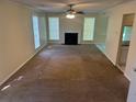 Spacious living room with carpet, bright windows, a ceiling fan, and a cozy fireplace at 5040 Brittany Dr, Stone Mountain, GA 30083