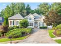 Beautiful two-story home with an inviting driveway and lush landscaping surrounding the property at 5059 Winding Hills Lane Ln, Woodstock, GA 30189