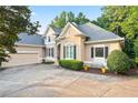 Charming home featuring a neutral facade, well-maintained landscaping, and an attached two-car garage at 5059 Winding Hills Lane Ln, Woodstock, GA 30189