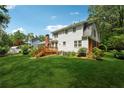 Expansive backyard featuring a wooden deck, lush green lawn, mature trees, and a home's exterior view at 626 Cheatham Sw Dr, Marietta, GA 30064