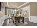 Elegant dining room features a tray ceiling, wainscoting, chandelier, and large windows at 1019 Avonley Creek Trce, Sugar Hill, GA 30518