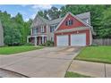 Lovely home featuring a long driveway leading to an attached garage and a well-maintained front lawn at 1019 Avonley Creek Trce, Sugar Hill, GA 30518