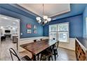 Stylish dining room with blue walls, wainscoting, tray ceiling, and a rustic wooden dining table at 2625 Harbor Point Ct, Cumming, GA 30041