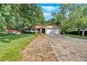 Charming single-story home with mature trees, lush lawn, two-car garage, and a brick and siding exterior at 4866 S Lilburn Stone Mountain Road Sw Rd, Lilburn, GA 30047