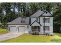 Charming two-story home with a two-car garage, black and white trim, and a well-manicured lawn at 6492 Swift Creek Road, Lithonia, GA 30058
