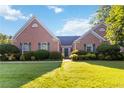 Inviting brick home with a well-manicured lawn and symmetrical landscaping at 10050 Lauren Hall Ct, Alpharetta, GA 30022