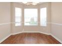 Bright dining nook featuring three windows, brown flooring, and neutral paint at 5942 Idlewood Pl, Lithonia, GA 30038