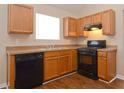 Functional kitchen featuring oak cabinets, modern appliances, and laminate floors at 5942 Idlewood Pl, Lithonia, GA 30038