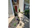 Sidewalk leading to the front door surrounded by a garden bed with a variety of flowers at 1447 Evanston, Marietta, GA 30062