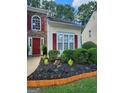 Close up of the front entrance featuring a garden bed and a red door with decorative shutters at 1447 Evanston, Marietta, GA 30062