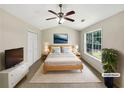Staged main bedroom features a large window and calming neutral decor at 268 Heathrow Dr, Riverdale, GA 30274