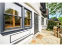 Close up of the entryway with charming wood shutters, stone porch, and a rustic black door at 1448 N Highland Ne Ave, Atlanta, GA 30306
