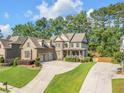 Stately two-story home featuring manicured lawns, mature trees and a convenient circular driveway at 4771 Moon Chase Dr, Buford, GA 30519