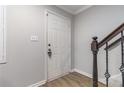 A bright entryway features wood-look flooring, a white door, and a staircase with dark wood handrail at 115 Winding River Dr # B, Atlanta, GA 30350