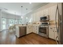 Bright kitchen with stainless steel appliances, white cabinetry, and hardwood flooring at 3275 Cherry Oak Ln, Cumming, GA 30041