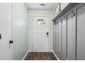 Welcoming foyer with wood-look floors, white door, paneled wall and convenient coat hooks at 200 Pine Tree Ln, Mcdonough, GA 30252