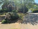 Charming two-story home with mature trees and classic brick accents, enhancing curb appeal at 4504 Allen Hollow, Suwanee, GA 30024