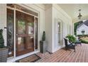Welcoming front porch with brick flooring, seating, and decorative glass front door at 1021 Bluffhaven Ne Way, Atlanta, GA 30319