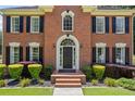 Close-up of brick home's entryway, showcasing front door and landscaping at 2500 Ashbourne Dr, Lawrenceville, GA 30043
