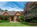 Attractive brick home with arched entryway, well-manicured lawn, and mature trees at 3505 Watson Rd, Cumming, GA 30028