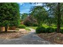 Pathway through beautifully landscaped yard with decorative stones and mature trees at 3505 Watson Rd, Cumming, GA 30028