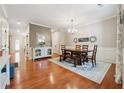 Formal dining room with hardwood floors, decorative wainscoting, traditional chandelier, and neutral color scheme at 6202 Oakdale Ridge Se Ct, Mableton, GA 30126