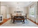 Well-lit dining room featuring stylish decor, a wooden dining set, and a decorative area rug over hardwood floors at 6202 Oakdale Ridge Se Ct, Mableton, GA 30126