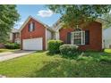 Charming brick home with green lawn and two-car garage on a sunny day at 876 Ashton Oak Cir, Stone Mountain, GA 30083