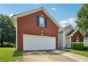 Brick home featuring a two-car garage and well-maintained landscaping at 876 Ashton Oak Cir, Stone Mountain, GA 30083