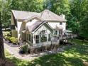 Exterior view showcasing a sunroom and a large deck with seating overlooking the expansive backyard at 4673 Jefferson Township Pl, Marietta, GA 30066