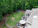 Aerial view of the backyard featuring a fire pit with chairs, a soccer goal, a deck with seating, and mature trees at 4673 Jefferson Township Pl, Marietta, GA 30066