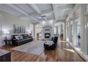 Bright living room with hardwood floors, coffered ceilings, fireplace, and large windows at 2160 Kensington Gates Nw Dr, Kennesaw, GA 30152