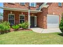Front door with lush landscaping, beautiful brickwork, and garage at 1147 Scenic Park Trl, Lawrenceville, GA 30046