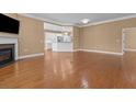 Open living area featuring hardwood floors, fireplace, and kitchen access at 3209 Telhurst Way, Buford, GA 30519